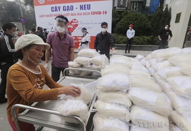 Trường Đại học Kinh tế Quốc dân phát tặng miễn phí gạo cho người nghèo từ nguồn kinh phí do cán bộ, nhân viên nhà trường đóng góp bằng 1 ngày lương của mỗi người để hỗ trợ người nghèo vượt qua đại dịch COVID-19. Ảnh: Trần Việt - TTXVN