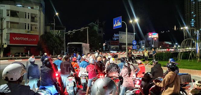 Trong ảnh: Dòng người đi xe máy chờ được chở qua cầu Bãi Cháy (ảnh chụp lúc 20h30, ngày 13/10). Ảnh: TTXVN