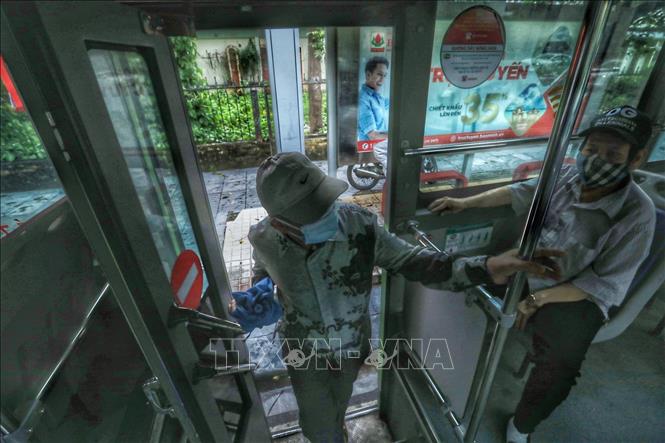 Trong ảnh: Khách lên xe buýt tại trạm đón, trả khách trên đường Nguyễn Trãi. Ảnh: Tuấn Anh - TTXVN