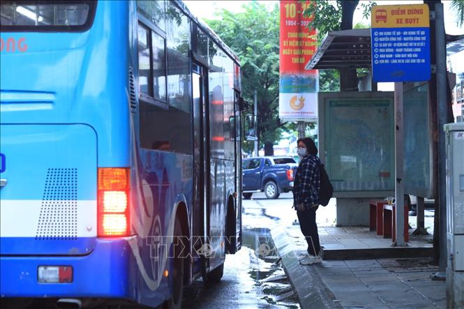 Trong ảnh: Khách lên xe buýt tại trạm đón, trả khách trên phố Giảng Võ. Ảnh: Tuấn Anh - TTXVN