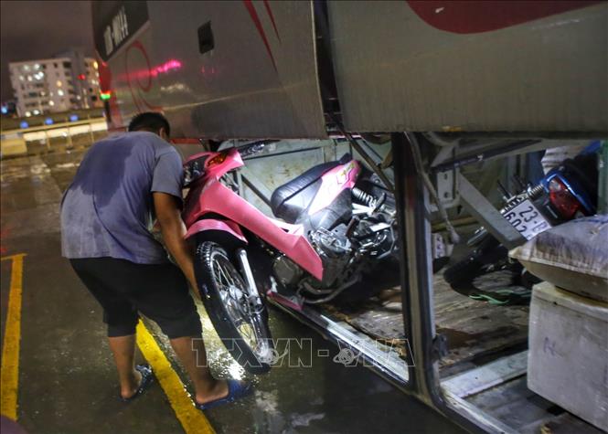 Có người mang cả xe máy về nhà. Ảnh: Tuấn Đức - TTXVN