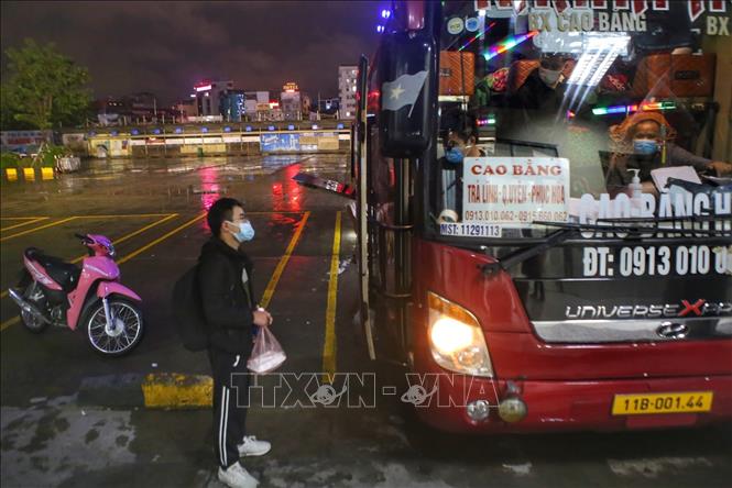 Phụ xe kiểm tra thông tin từng hành khách lên xe. Ảnh: Tuấn Đức - TTXVN