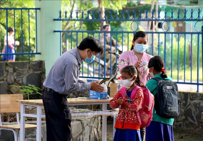 Trong ảnh: Thầy cô giáo trường Tiểu học và Trung học cơ sở Đông Tiến (xã Đông Tiến) hướng dẫn các em sát khuẩn tay trước khi vào lớp. Ảnh: Nguyễn Thanh – TTXVN
