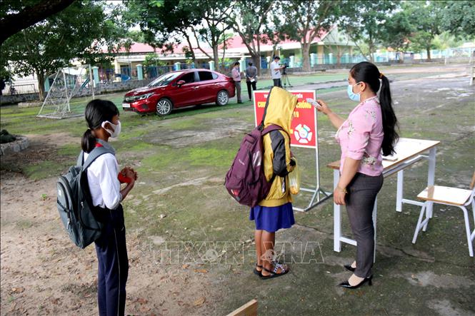 Trong ảnh: Đo thân nhiệt cho học sinh trường Tiểu học và Trung học cơ sở Đông Tiến (xã Đông Tiến) trước khi vào lớp. Ảnh: Nguyễn Thanh – TTXVN