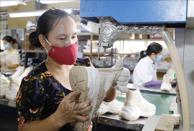 Dây chuyền hoàn thiện giày xuất khẩu tại nhà máy của Công ty giày Trường Xuân. Ảnh: Trần Việt - TTXVN