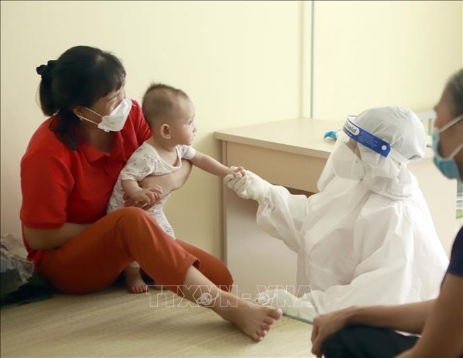 Trong ảnh: Nhân viên y tế vui đùa với một cháu nhỏ tại Trung tâm đào tạo vận động viên Vĩnh Phúc. Ảnh: Hoàng Hùng - TTXVN

