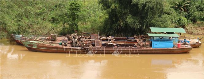 Trong ảnh: Những chiếc thuyền neo đậu dọc bờ sông đoạn giáp ranh, chờ đêm xuống để bơm hút cát trái phép. Ảnh: Sỹ Tuyên – TTXVN