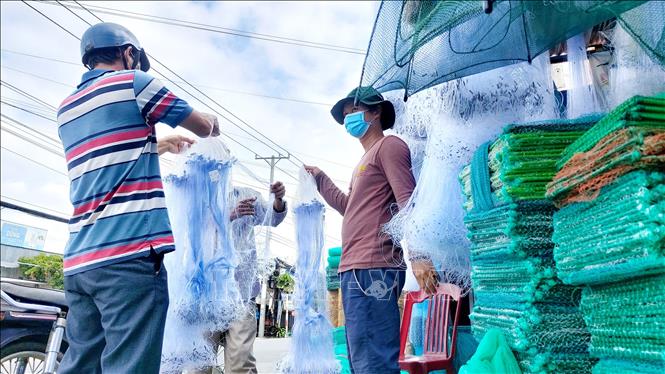 Anh Phạm Phước Công (phải), chủ cơ sở sản xuất lưới, lú ở Tân Hưng cho biết năm nay số lượng lưới, lú làm ra giảm khoảng 30% so với mọi năm. Ảnh: Thu Hiền - TTXVN