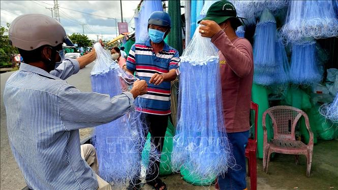 Giá lưới các loại năm nay không tăng nhưng do ảnh hưởng dịch bệnh, cộng với nước lũ về muộn, mực nước thấp, cá ít nên nhu cầu mua ngư cụ đánh bắt thủy sản mùa nước nổi sụt giảm. Ảnh: Thu Hiền - TTXVN