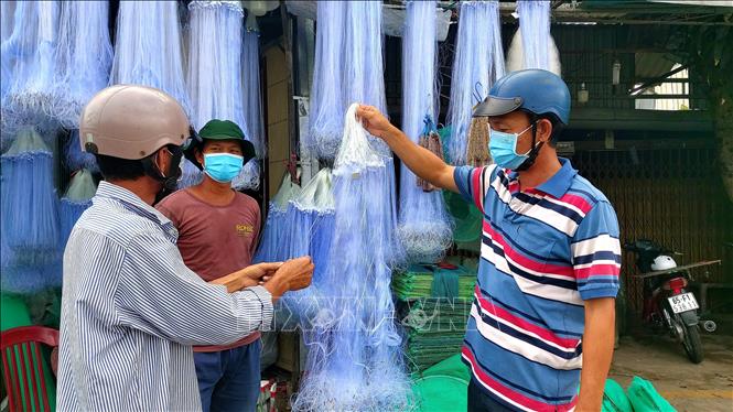 Người mua lưới cân nhắc số lượng lưới khi mua vì năm nay nước lũ tràn đồng thấp, lượng cá ít. Ảnh: Thu Hiền - TTXVN