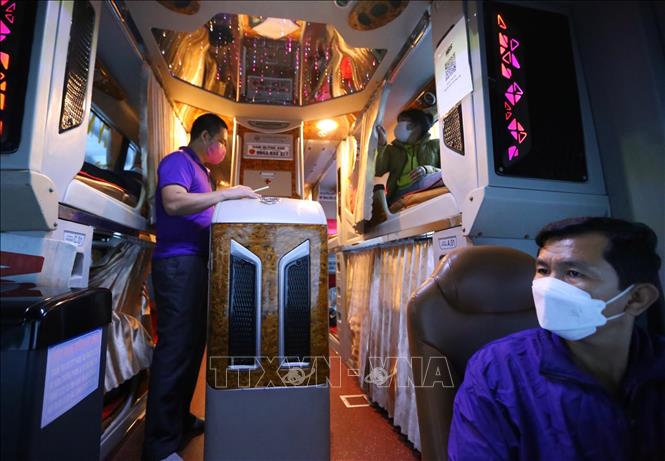 Tất cả lái xe, phụ xe và hành khách đều bắt buộc đeo khẩu trang để phòng, chống dịch COVID-19 (ảnh chụp trên xe của Công ty Nam Quỳnh Anh xuất phát từ Bến xe Nước Ngầm). Ảnh: Hoàng Hiếu - TTXVN 