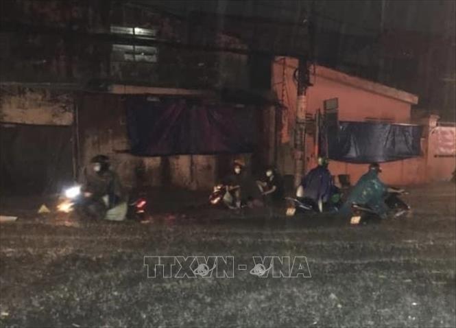 Người dân “ngụp lặn” giữa dòng nước trên đường Phan Anh (quận Bình Tân). Ảnh: Hồng Giang - TTXVN