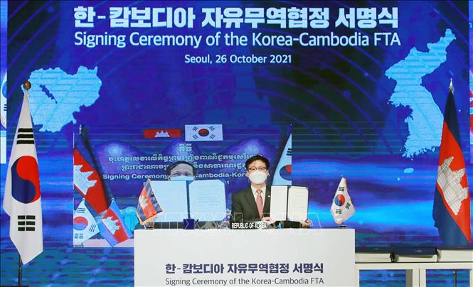 Trong ảnh: Bộ Thương mại Hàn Quốc Yeo Han-koo (phải) và người đồng cấp Campuchia Pan Sorasak (trên màn hình) tại lễ ký trực tuyến Hiệp định thương mại tự do (FTA) Hàn Quốc - Campuchia ngày 26/10/2021. Ảnh: Yonhap/ TTXVN