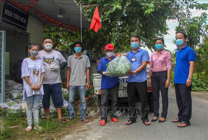 Trong ảnh: Anh Minh Trung trao rau củ cho lãnh đạo phường Thới An Đông, quận Bình Thủy để hỗ trợ lại cho người dân khó khăn trên địa bàn. Ảnh: Thanh Liêm - TTXVN