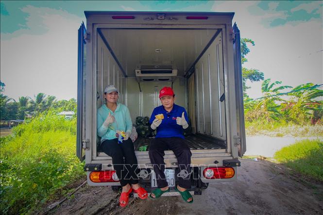 Tronga rnh: Vợ chồng anh Minh Trung cùng chiếc xe tải được một cơ sở bánh mì ở quận Ninh Kiều cho mượn để anh chở hàng từ thiện trong mùa dịch. Ảnh: Thanh Liêm - TTXVN