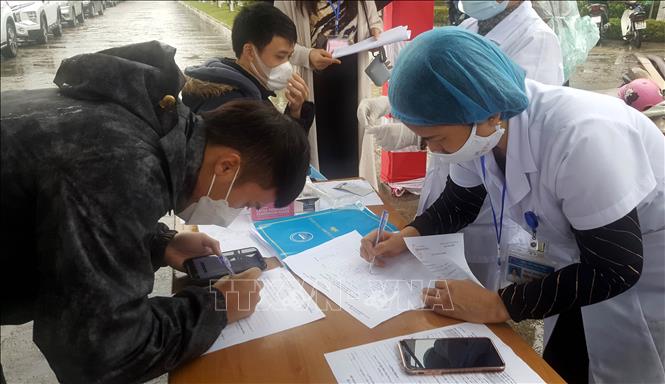 Trong ảnh: Các thí sinh làm thủ tục khai báo y tế trước khi vào điểm thi. Ảnh: Nguyễn Công Hải – TTXVN