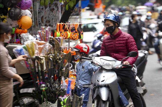 Các em nhỏ được phụ huynh mua đồ chơi Halloween. Ảnh: Tuấn Đức - TTXVN