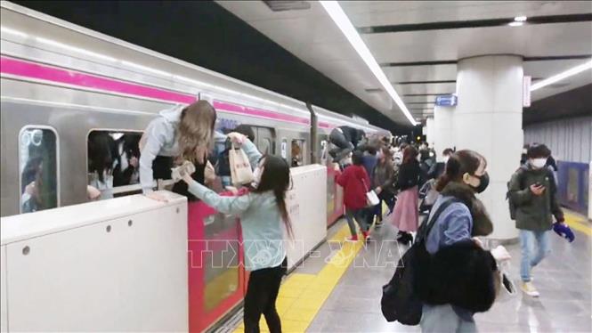 Trong ảnh: Hành khách hoảng loạn tìm cách tháo chạy ra khỏi toa tàu điện ngầm Keio ở thủ đô Tokyo, Nhật Bản sau vụ tấn công tối 31/10/2021. Ảnh: Kyodo/TTXVN