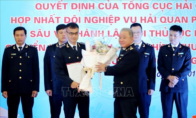 Phó cục trưởng Cục Hải quan Lạng Sơn Nguyễn Hữu Vượng (bên phải) tặng hoa chúc mừng đội nghiệp vụ hải quan mới được hợp nhất. Ảnh: Thái Thuần - TTXVN