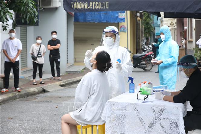 Trong ảnh: Nhân viên y tế lấy mẫu xét nghiệm COVID-19 cho các trường hợp liên quan đến F0 trên địa bàn xã Ninh Hiệp. Ảnh: Minh Quyết - TTXVN