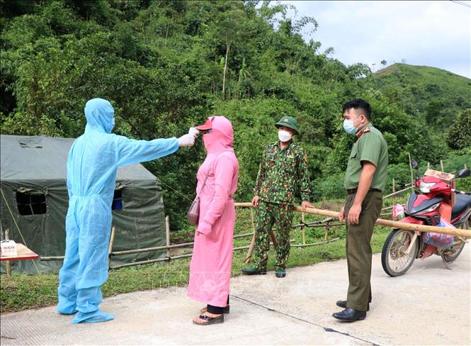 Đo thân nhiệt đối với người dân sinh sống trên địa bàn xã Na Tông (huyện Điện Biên, tỉnh Điện Biên) khi qua chốt chặn kiểm soát phòng, chống dịch COVID-19. Ảnh: Xuân Tiến – TTXVN 

