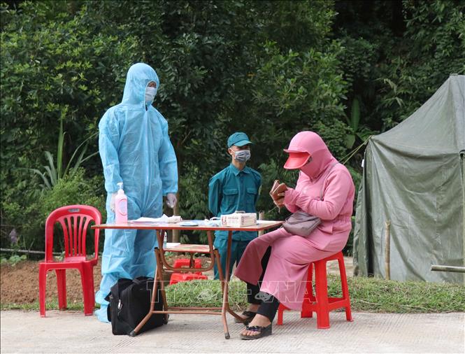 Người dân thực hiện thủ tục khai báo y tế, trình giấy tờ tùy thân, giấy xác nhận tiêm vaccine phòng dịch COVID-19 tại chốt kiểm soát phòng, chống dịch bản Hát Tao (xã Na Tông, huyện Điện Biên, tỉnh Điện Biên). Ảnh: Xuân Tiến – TTXVN 