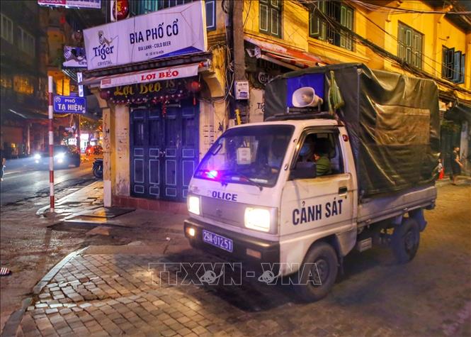 Lực lượng công an phường đi kiểm tra, nhắc nhở các hàng quán tại phố Tạ Hiện, quận Hoàn Kiếm. Ảnh: Tuấn Đức - TTXVN