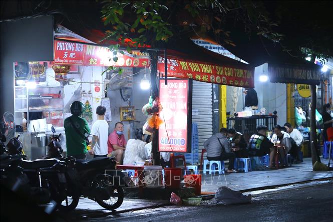 Lúc 21h20, một cửa hàng bán đồ ăn uống trên phố Hàng Chiếu, quận Hoàn Kiếm vẫn còn nhiều khách. Ảnh: Hoàng Hiếu - TTXVN 