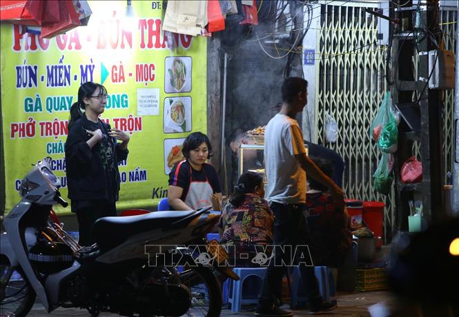 Lúc 21h20, một cửa hàng ăn uống trên phố Hàng Chiếu, quận Hoàn Kiếm vẫn sáng đèn phục vụ khách. Ảnh: Hoàng Hiếu - TTXVN 