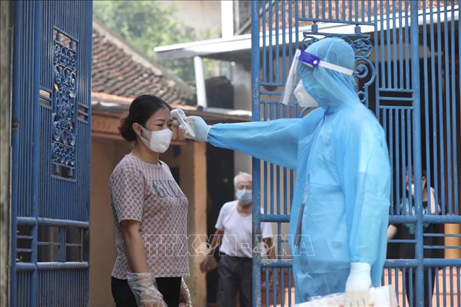 Trong ảnh: Hằng ngày, nhân viên y tế đến kiểm tra thân nhiệt cho người dân trong khu phong toả 2 lần. Ảnh: Minh Quyết - TTXVN