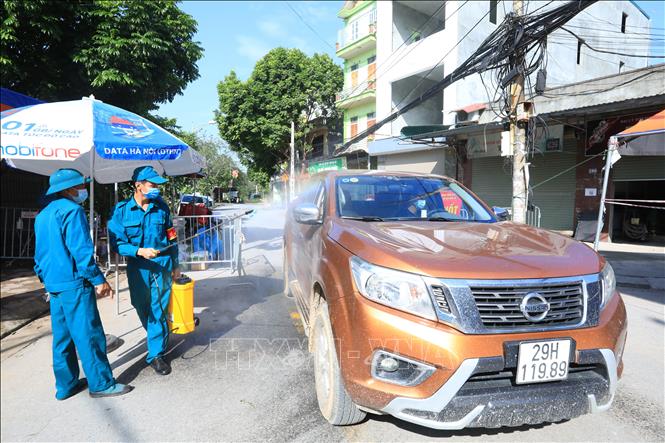 Trong ảnh: Các phương tiện ra, vào khu vực cách ly đều được phun khử khuẩn đảm bảo phòng, chống dịch. Ảnh: Tuấn Anh - TTXVN