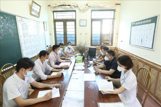 Trong ảnh: Thành viên trạm y tế lưu động họp, triển khai kế hoạch tại điểm phong toả Thị trấn Quốc Oai. Ảnh: Minh Quyết - TTXVN