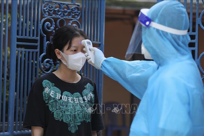 Trong ảnh: Hằng ngày, nhân viên y tế đến kiểm tra thân nhiệt cho người dân trong khu phong toả 2 lần. Ảnh: Minh Quyết - TTXVN
