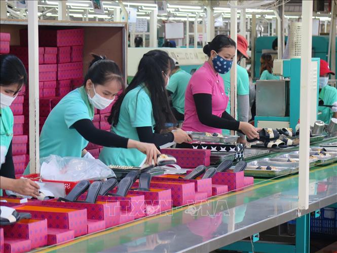 Công nhân nhà máy công ty TNHH Victory International (Việt Nam) đang hoàn thiện khâu đóng gói sản phẩm giày da nữ xuất khẩu. Ảnh: Minh Hưng-TTXVN