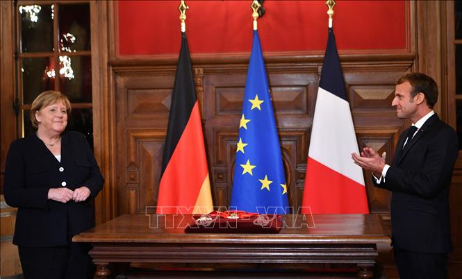 Trong ảnh: Thủ tướng Đức Angela Merkel (trái) và Tổng thống Pháp Emmanuel Macron (phải) trong buổi lễ chia tay ở thị trấn Beaune thuộc vùng Bourgogne, Pháp ngày 3/11/2021. Ảnh: AFP/TTXVN