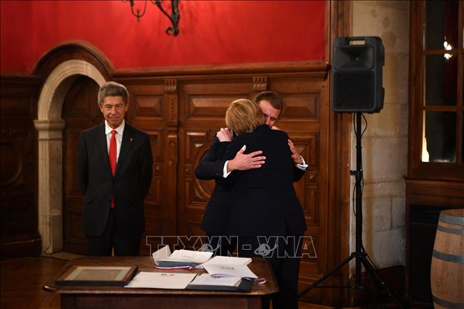 Trong ảnh: Thủ tướng Đức Angela Merkel (phải) cùng phu quân Joachim Sauer (trái) trong buổi lễ chia tay Tổng thống Pháp Emmanuel Macron (giữa) ở thị trấn Beaune thuộc vùng Bourgogne, Pháp ngày 3/11/2021. Ảnh: AFP/TTXVN