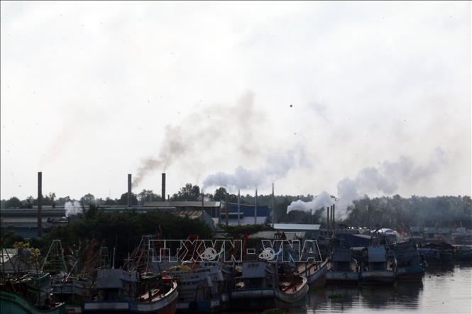 Trong ảnh: Khói thải mù mịt xả ra từ các nhà máy bột cá nằm dọc sông Cái Bé. Ảnh: Lê Sen - TTXVN