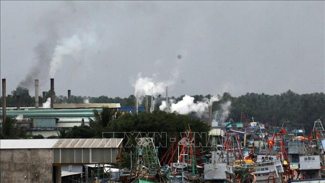 Trong ảnh: Khói thải mù mịt xả ra từ các nhà máy bột cá nằm dọc sông Cái Bé. Ảnh: Lê Sen - TTXVN