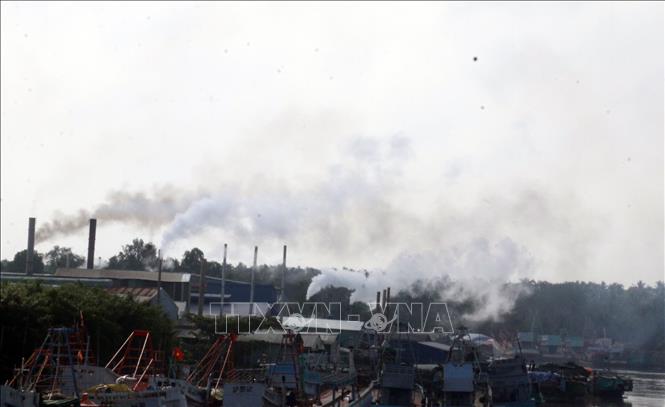 Trong ảnh: Khói thải mù mịt xả ra từ các nhà máy bột cá nằm dọc sông Cái Bé. Ảnh: Lê Sen - TTXVN