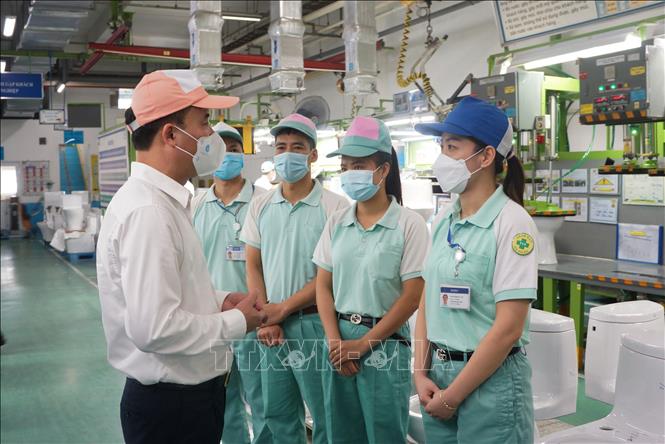 Trong ảnh: Tổng giám đốc Bảo hiểm xã hội Việt Nam Nguyễn Thế Mạnh với các công nhân lao động. Ảnh: TTXVN phát 