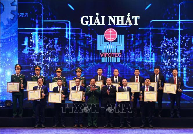 Trong ảnh: Bộ trưởng Bộ Khoa học và Công nghệ Huỳnh Thành Đạt và Thứ trưởng Bộ Quốc phòng Lê Huy Vịnh với các nhóm tác giả đạt giải Nhất. Ảnh: Hoàng Hiếu - TTXVN 
