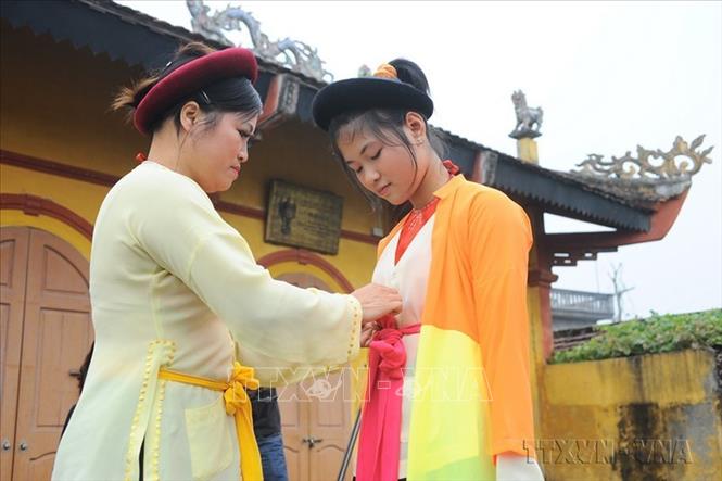 Thế hệ nghệ sỹ sau nối tiếp thế hệ trước, giữ nghề bằng cách truyền nghề trực tiếp, bắt tay chỉ ngón, dạy từng cách diễn, cách hát hay trang phục biểu diễn. Trong ảnh: Nghệ nhân Vũ Thị Lan (bên trái), làng Khuốc, xã Phong Châu, huyện Ðông Hưng (Thái Bình) được coi là nơi khởi nguồn của Chèo, hướng dẫn cháu Hoàng Mai Trang cách mặc trang phục chèo truyền thống. Ảnh: Minh Đức – TTXVN