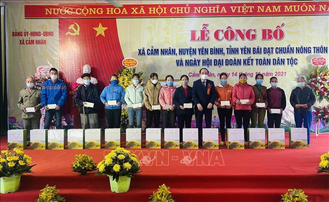Tặng quà cho các hộ nghèo, hộ khó khăn có thành tích trong xây dựng nông thôn mới tại xã Cẩm Nhân. Ảnh: Tuấn Anh-TTXVN