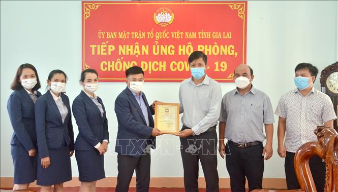 Trong ảnh: Phó Chủ tịch Ủy ban Mặt trận Tổ quốc Việt Nam tỉnh Gia Lai Đinh Ngọc Hải trao tặng bảng ghi nhận Tấm lòng vàng cho đại diện Ngân hàng Thương mại Cổ phần Quân đội - Chi nhánh Gia Lai. Ảnh: Quang Thái- TTXVN