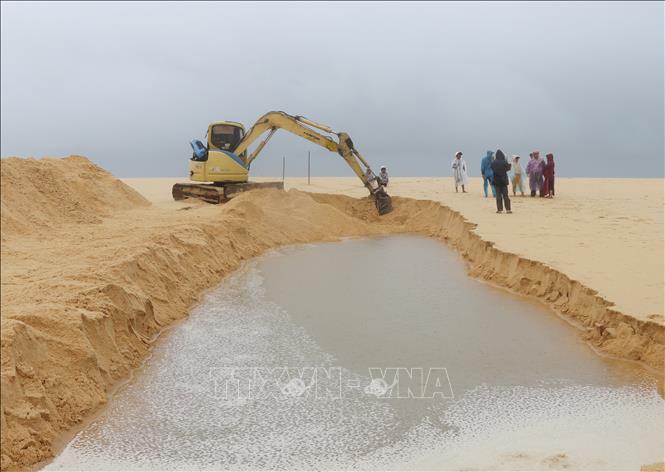 Trong ảnh: Người dân thôn Phú Lương, xã An Ninh Đông, huyện Tuy An, Phú Yên thuê xe múc khơi thông cửa biển An Hải, xã An Hòa Hải cứu vùng nuôi thủy sản. Ảnh: Phạm Cường-TTXVN

