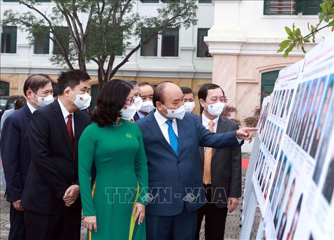 Chủ tịch nước Nguyễn Xuân Phúc xem trưng bày ảnh do Thông tấn xã Việt Nam và Học viện Nông nghiệp Việt Nam phối hợp tổ chức. Ảnh: Thống Nhất- TTXVN