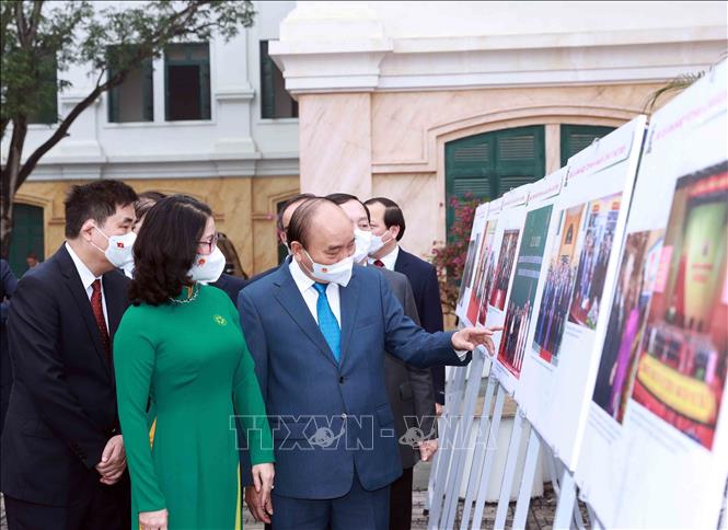 Chủ tịch nước Nguyễn Xuân Phúc xem trưng bày ảnh do Thông tấn xã Việt Nam và Học viện Nông nghiệp Việt Nam phối hợp tổ chức. Ảnh: Thống Nhất- TTXVN
