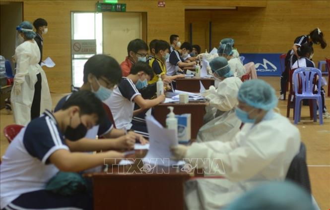 Học sinh làm thủ tục tiêm vaccine tại Cung thể Thao Tiên Sơn. Ảnh: Văn Dũng - TTXVN