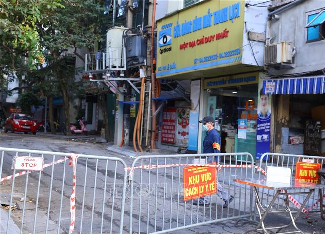 Trong ảnh: Lực lượng chức năng trực chốt tại điểm phong tỏa phố Đỗ Hành cắt phố Lê Duẩn (ảnh chụp chiều 21/11). Ảnh: Hoàng Hiếu - TTXVN 