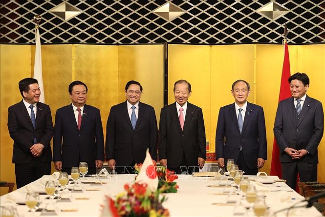 Photo: Prime Minister Pham Minh Chinh, former Japanese PM Suga Yoshihide and Chairman of the Japan - Vietnam Parliamentary Friendship Alliance Nikai Toshihiro attend an event marking the export of the Unshu mandarin, a specialty fruit of Japan, to Vietnam. VNA Photo: Dương Giang